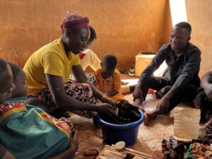 A mother washing a doll in a blue bucket