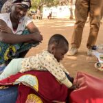 child playing on their stomach with mother smiling