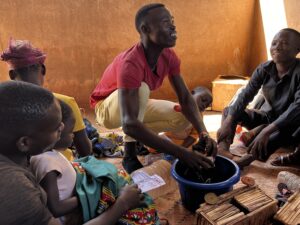 A father with his hands in a blue basin pretending to wash his baby